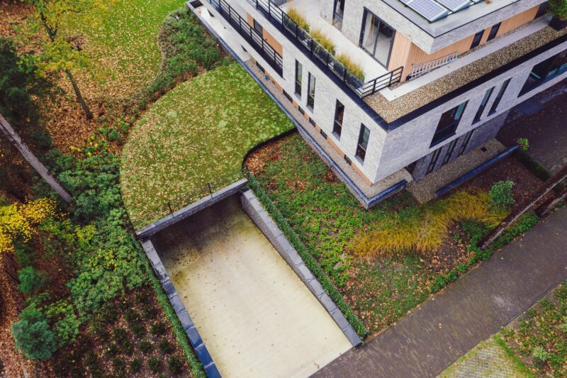 Bovenaanzicht: luchtfoto van zedumdak van moderne appartementenvilla met bosrijke omgeving in Den Dolder