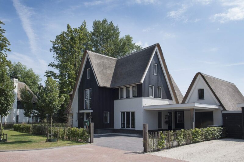 Zijaanzicht van unieke villa met rieten dak op Naardereiland in Naarden