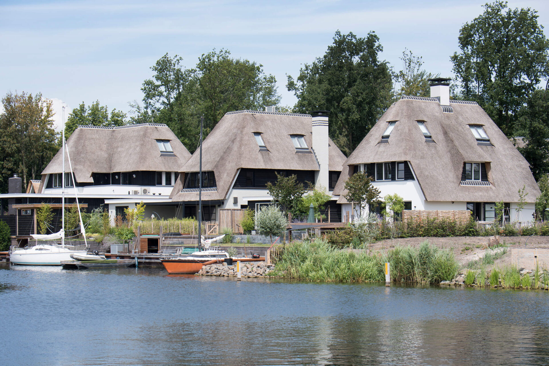 Drie luxe, rietgedekte villa's aan het water op Naardereiland