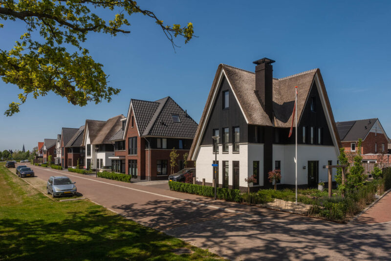 Sfeerbeeld en zijaanzicht van rietgedekte woning binnen Nieuw Boorn